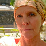Claudia Mens, Initiatiefnemer Inclusie Collectief Delft, een vrouw met oranje hoofddoek in het zonlicht.