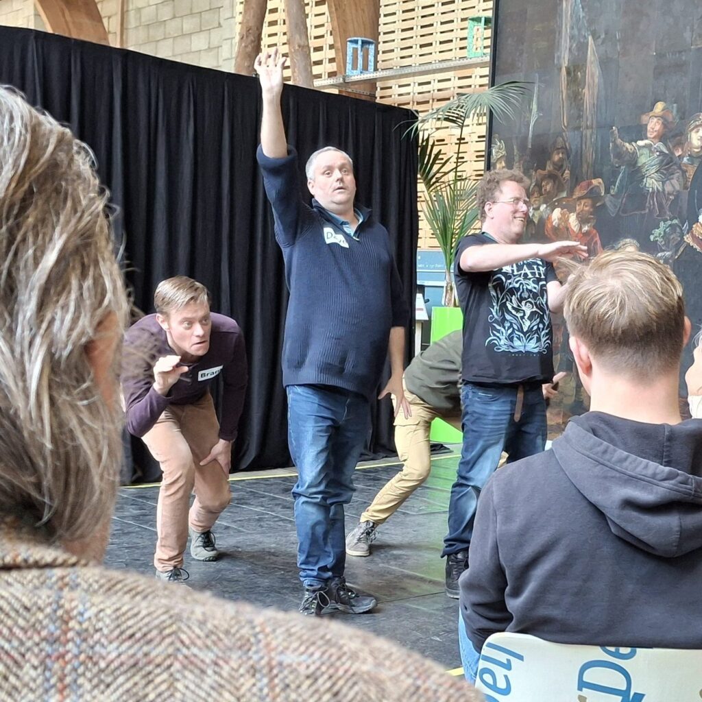 Dans- of theaterscène met deelnemers in zaal.